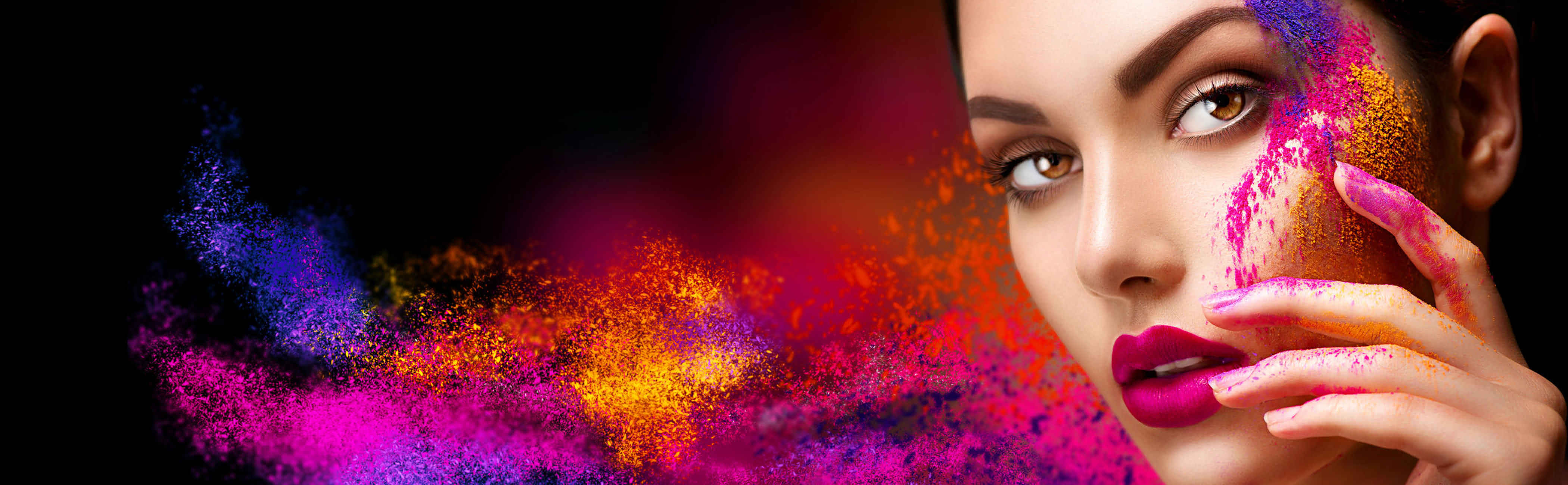 Young woman with coloured powder blowing off her face, showing the art of sales and marketing.
