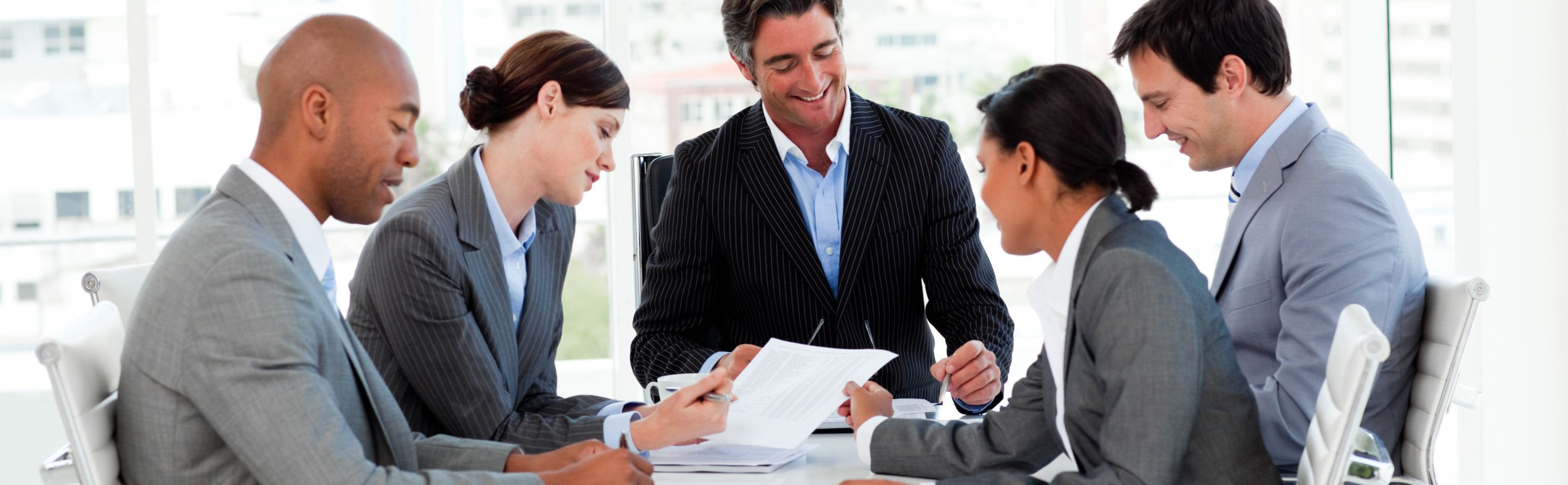 A team sitting around the table working on a sales pitch.