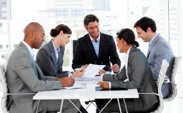 A team sitting around the table working on a sales pitch.